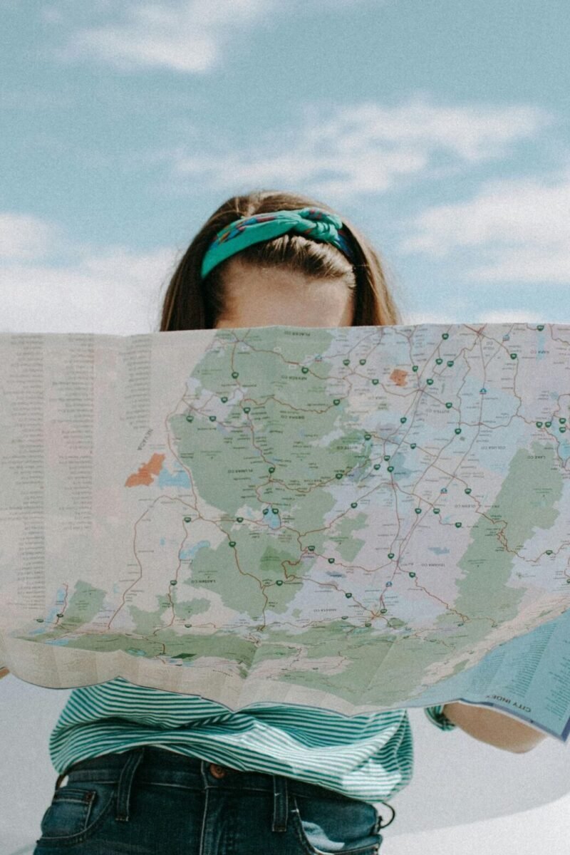 A woman holds a map while traveling through the scenic desert of California, USA.